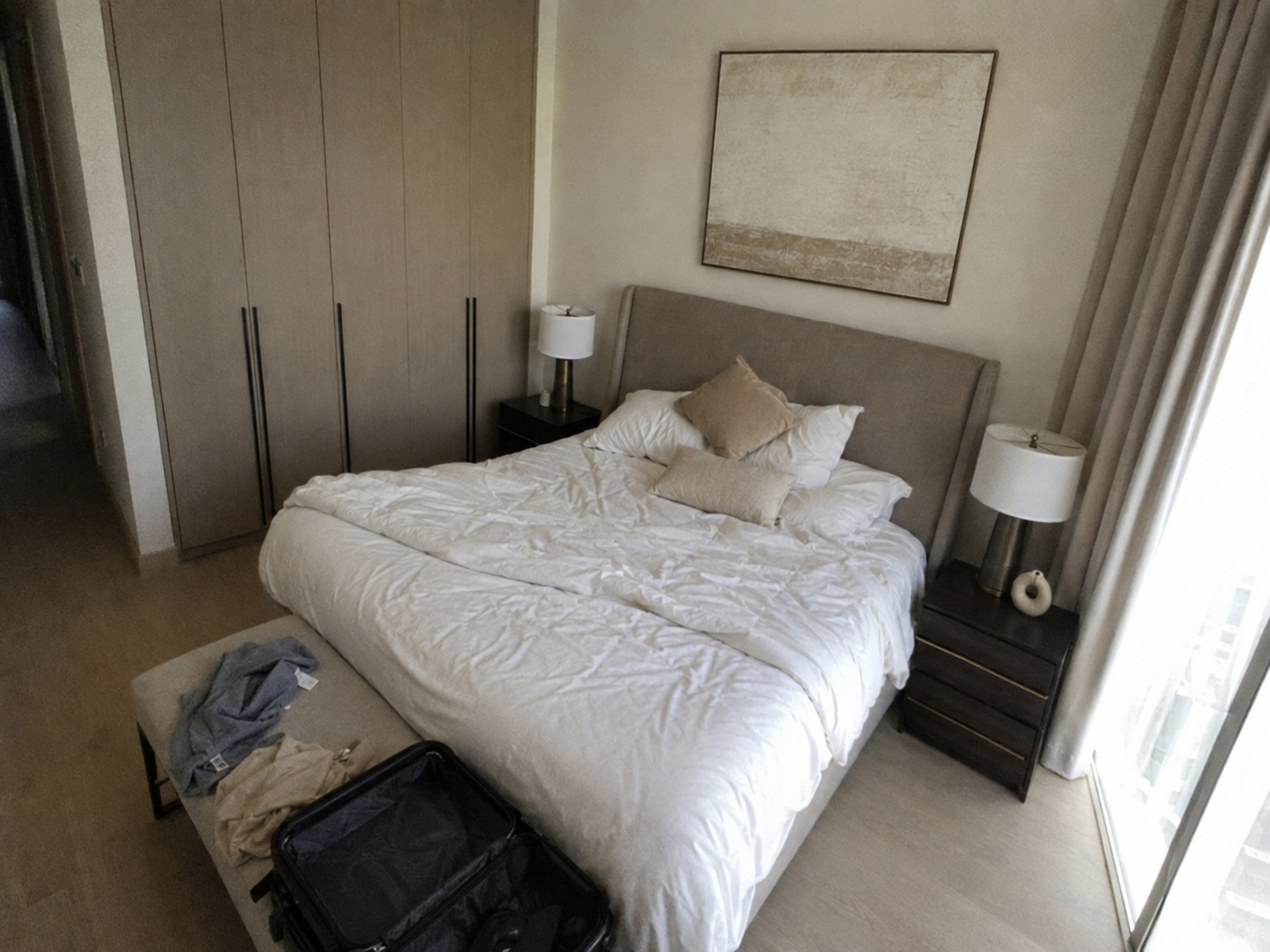 AI-generated bedroom with an unmade bed, luggage and an awkward high angle